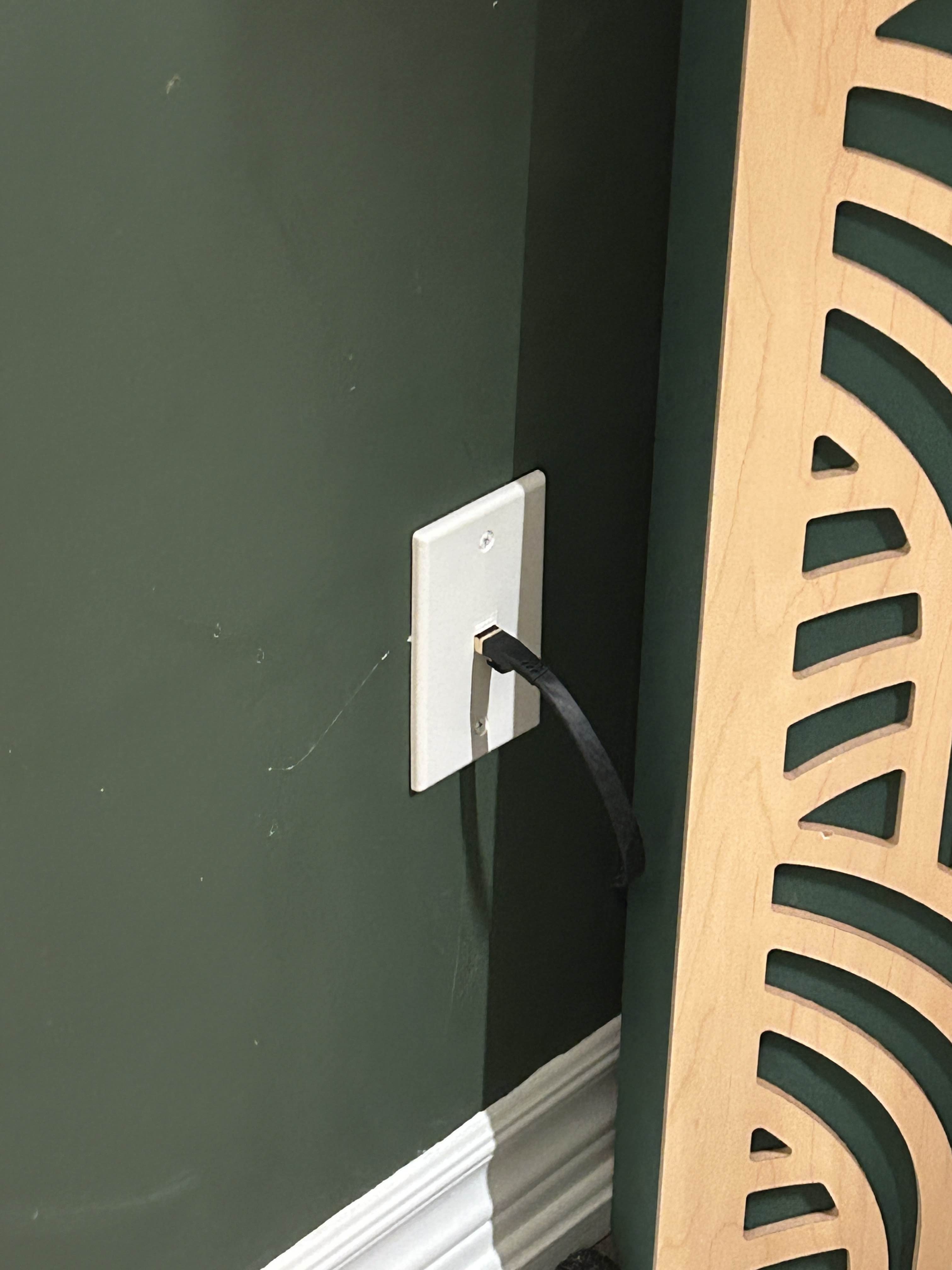 An ethernet port installed in a green wall