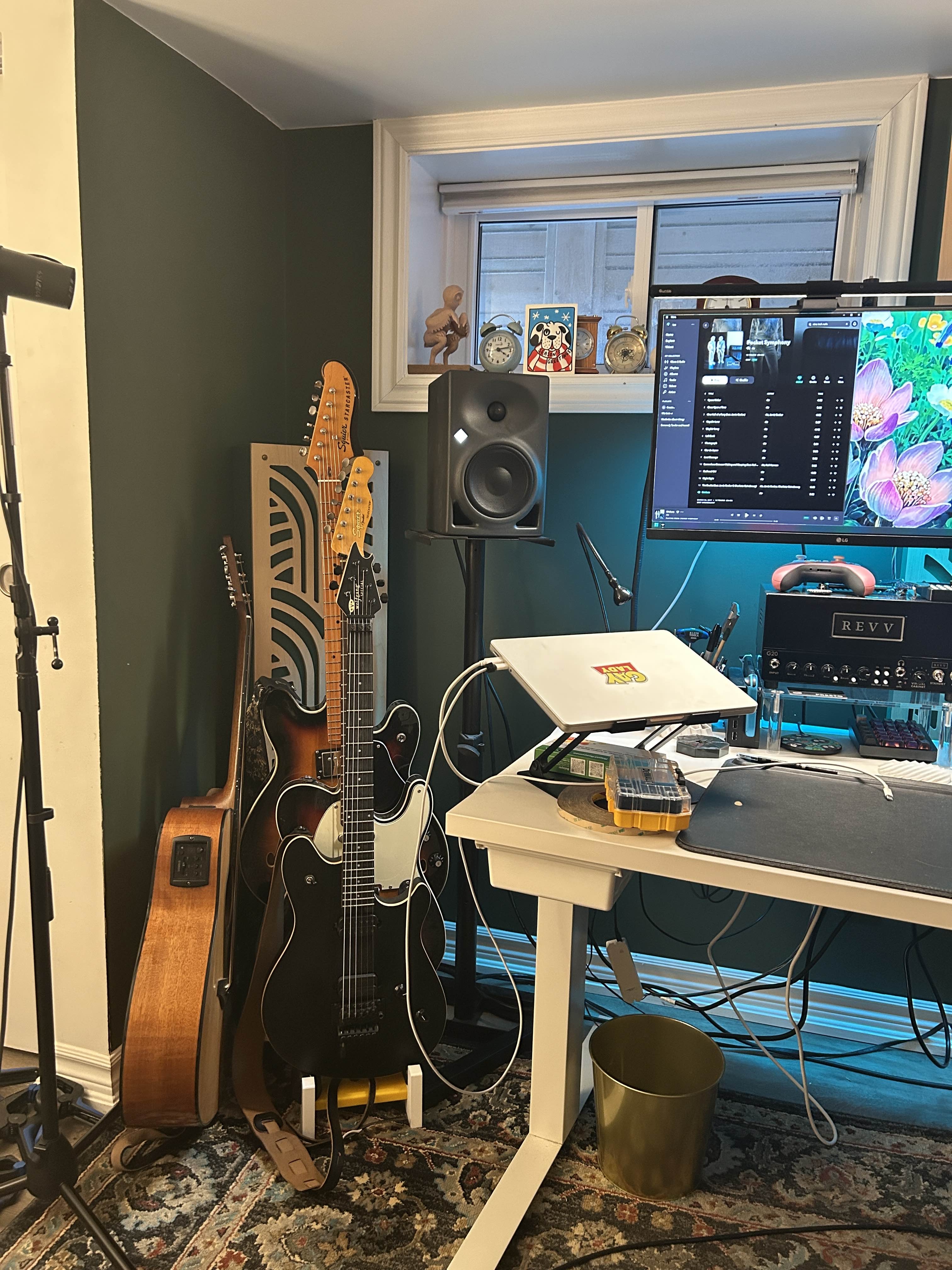 A 3-tier guitar stand with some electric guitars on it. Please ignore the clutter.